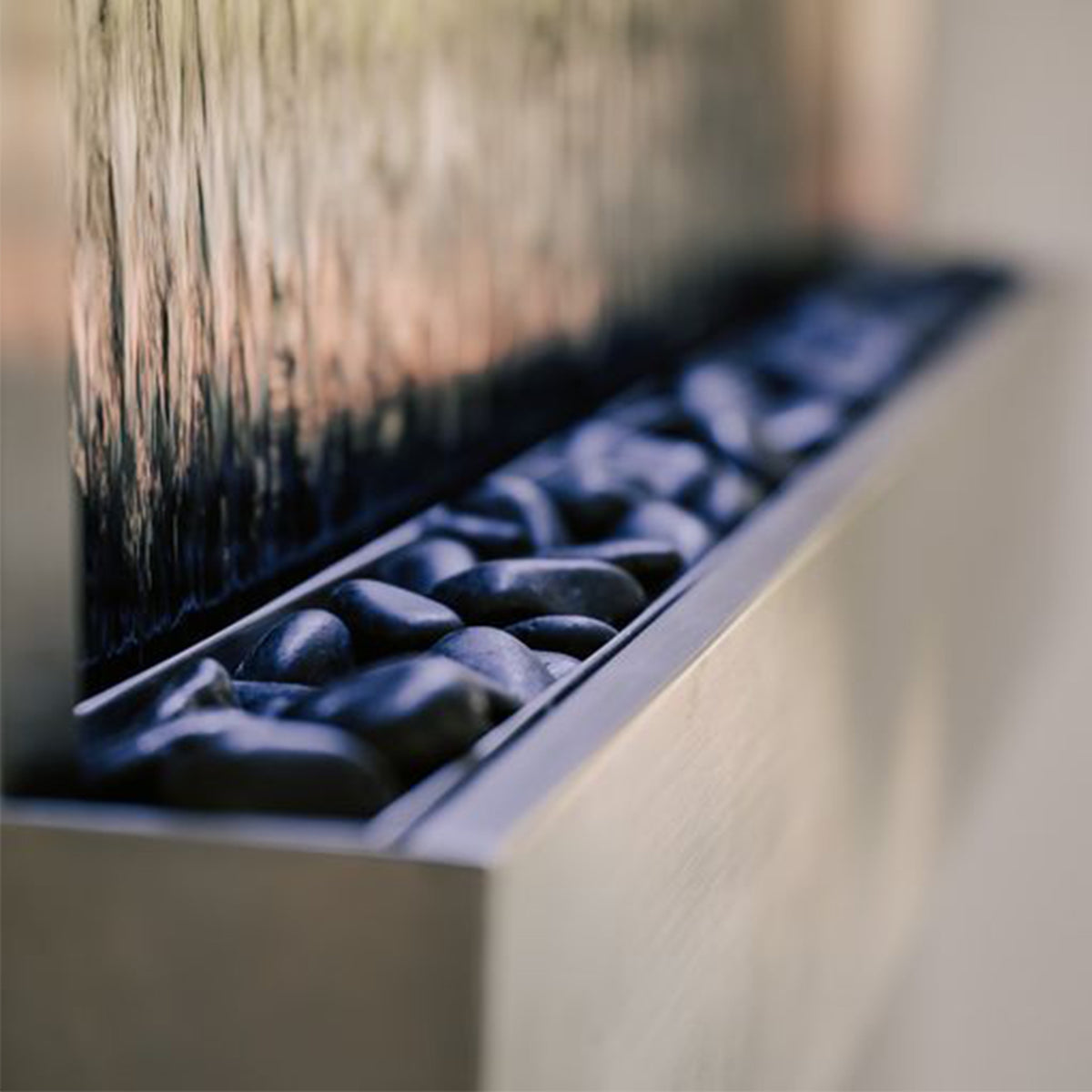 Close-up of cascading water and LED glow on wall-mounted mirror fountain